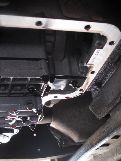 1995 Ford Bronco - Close-up of a transmission pan gasket with fluid drips, revealing a part number.