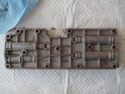 1995 Ford Bronco - A metal transmission valve body with visible Ford branding and part numbers is shown.