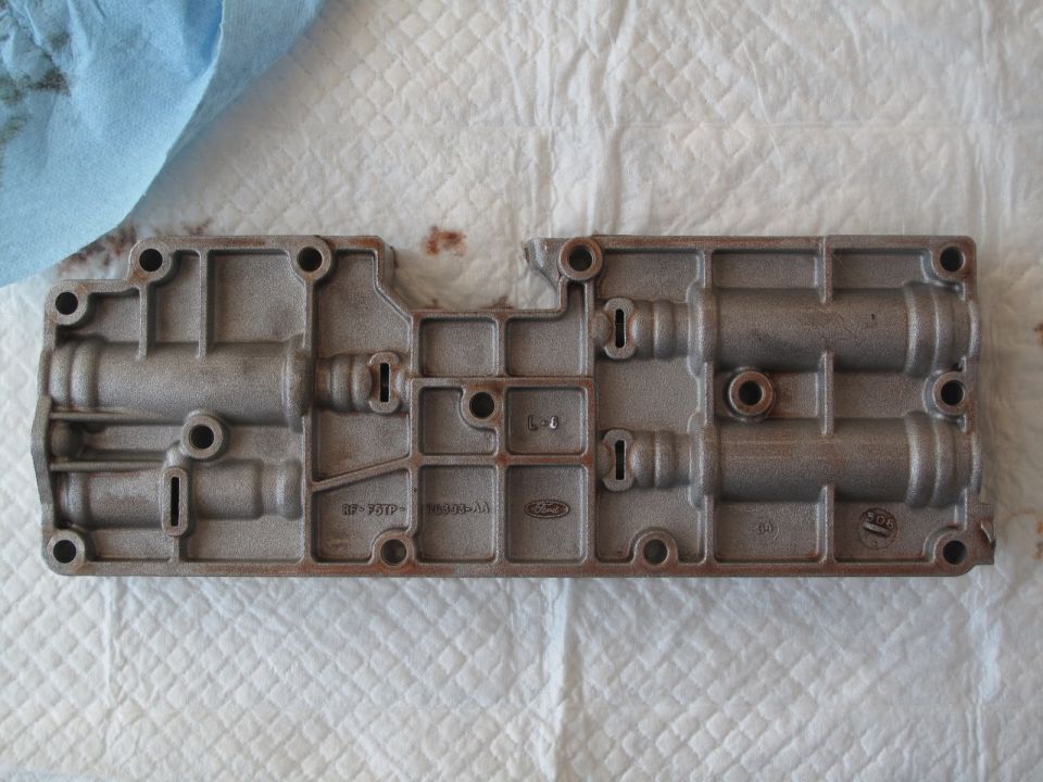 Metal transmission valve body with Ford logo and part numbers