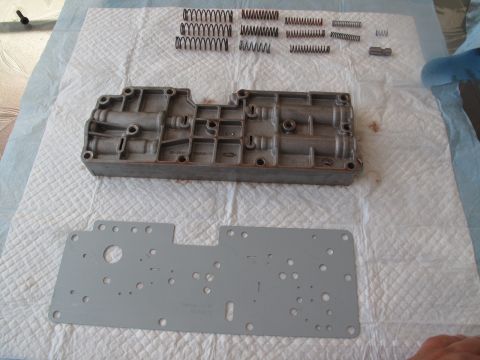 1995 Ford Bronco - Disassembled transmission valve body and associated springs and gasket are laid out for service.