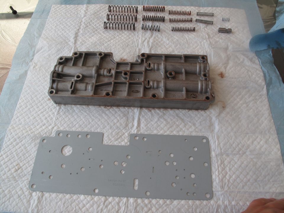Transmission valve body disassembled with springs and gasket laid out on paper towels