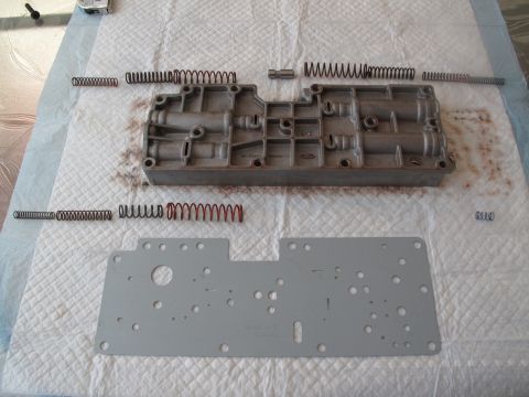 1995 Ford Bronco - Disassembled transmission valve body and gasket with springs, ready for service.