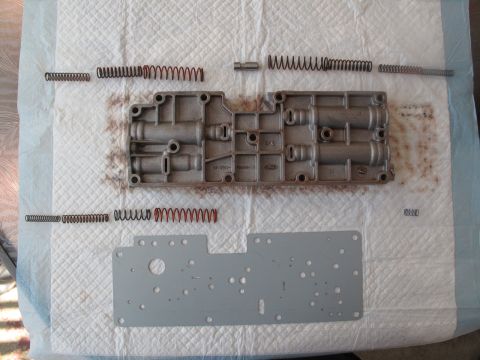 1995 Ford Bronco - Disassembled transmission valve body and springs laid out on a mat.