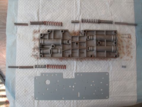 1995 Ford Bronco - Disassembled transmission valve body with springs and gasket plate.