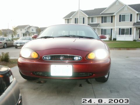 1998 Mercury Sable - Front view of a red 1998 Mercury Sable parked outside residential buildings.