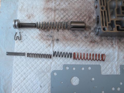 1995 Ford Bronco - Disassembled transmission valve body components, including various springs and a plunger, laid out on a towel.
