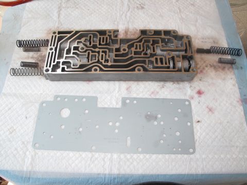 1995 Ford Bronco - Disassembled transmission valve body and gasket with springs, ready for cleaning or repair.
