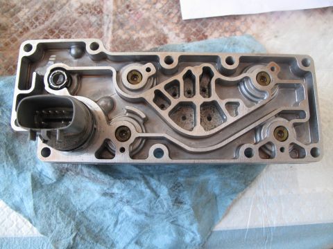 1995 Ford Bronco - Transmission control module with intricate internal channels and an electrical connector is shown on a blue cloth.