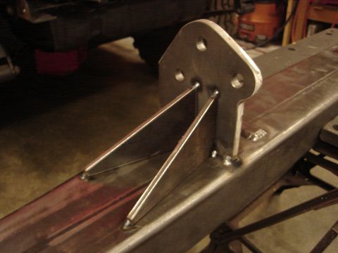 1989 Ford Bronco - Close-up of a custom fabricated metal bracket, likely for off-road modification, welded onto a vehicle's frame rail.