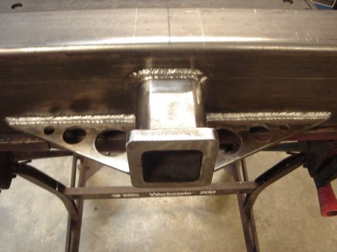1989 Ford Bronco - Close-up of a welded trailer hitch receiver attached to a metal beam, supported by triangular brackets.