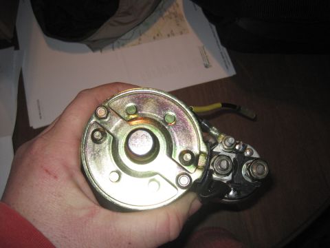 1979 Ford Bronco - A person is holding a metal starter motor with electrical connections visible.