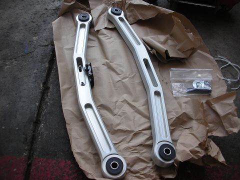 2004 Ford Crown Victoria - Metco Watts link arms and hardware laid out on brown paper.