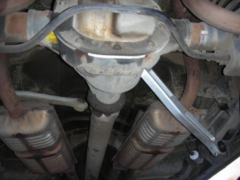 2004 Ford Crown Victoria - Underside view of a vehicle's rear axle and exhaust system, showing an aftermarket brace installation.