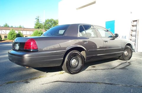 2001 Ford Crown Victoria - Side view of a gray 2001 Ford Crown Victoria parked outdoors.