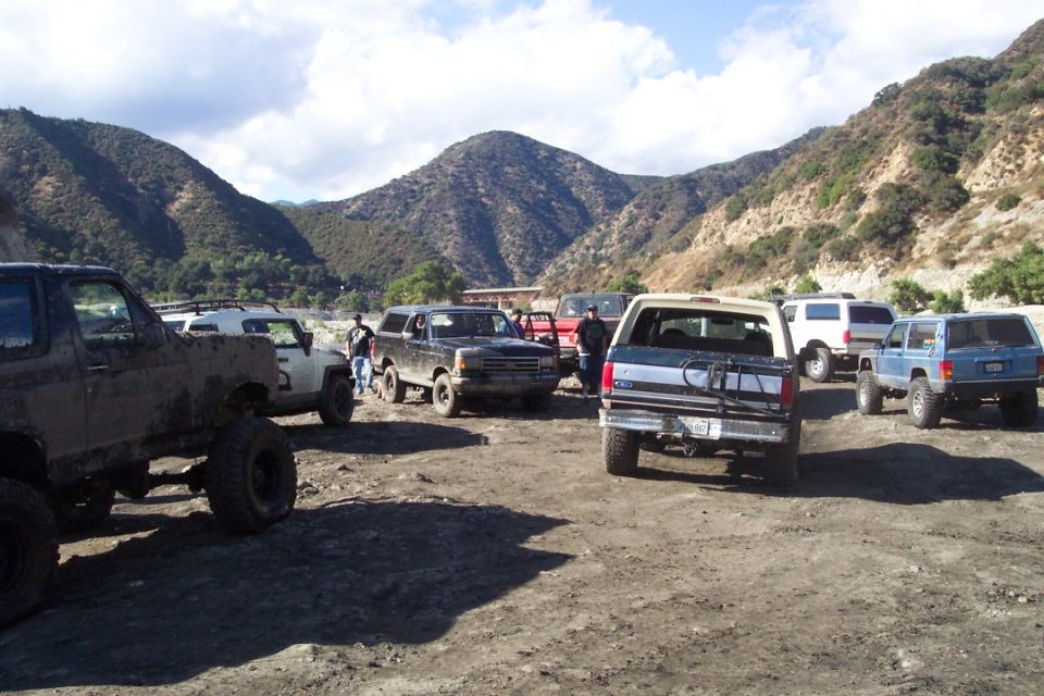 1995 Ford Bronco and other off-road vehicles parked in a dusty lot