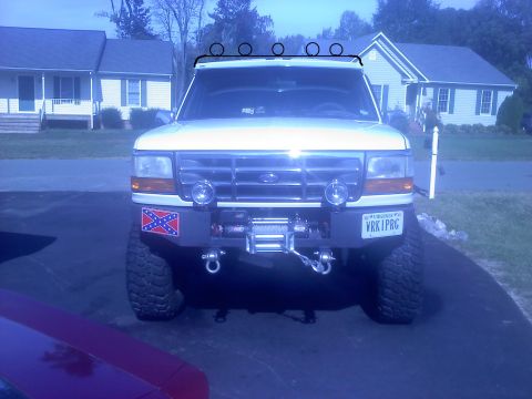 1996 Ford Bronco - This white Ford Bronco features a winch and auxiliary lights on its front bumper.
