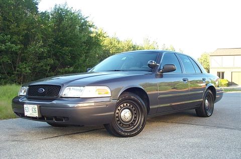 2001 Ford Crown Victoria - A dark gray 2001 Ford Crown Victoria is shown from a three-quarter front angle.