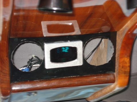 1992 Ford C-350 (Centurion Conversions) - Close-up of a custom wooden dashboard with a digital display and speaker openings.