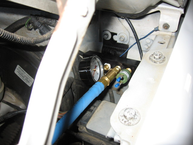 manifold up on drivers side by hood hinge.