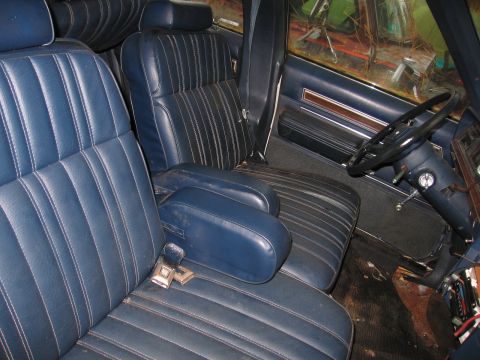 1991 Ford LTD Crown Victoria - The interior of a car shows blue vinyl seats and a dashboard with a steering wheel.