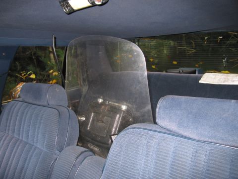 1991 Ford LTD Crown Victoria - The interior of a car, blue upholstered seats and a clear plastic divider.