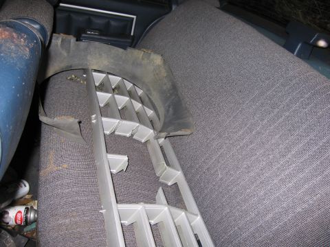 1991 Ford LTD Crown Victoria - A detached grille lies on the patterned seats inside a vehicle's interior.