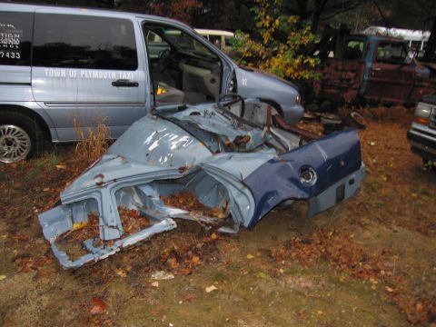 1991 Ford LTD Crown Victoria - Junkyard scene with a heavily damaged car body and multiple other vehicles visible.
