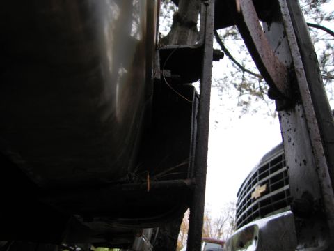 1991 Ford LTD Crown Victoria - A portion of a truck's front end is visible behind some dark, rusty metal structures.