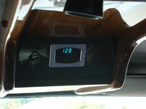 1992 Ford C-350 (Centurion Conversions) - A digital gauge displays '128' within the interior of a vehicle, surrounded by wood trim.