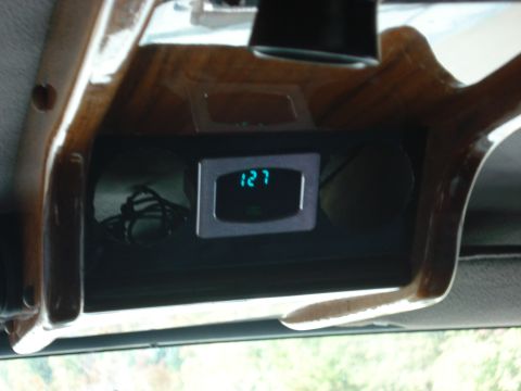 1992 Ford C-350 (Centurion Conversions) - Close-up of a vehicle's interior showing a digital clock and wood trim accents.
