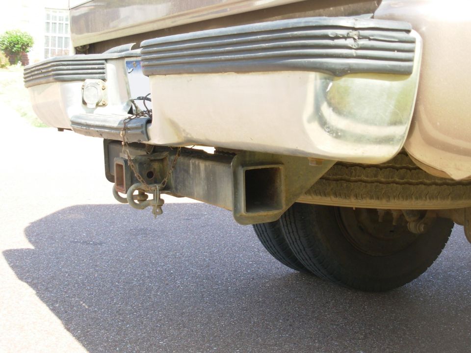 Rear bumper and trailer hitch receiver of a tan dually truck
