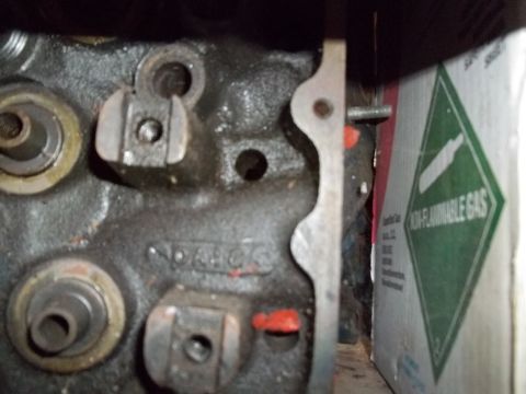 1972 Ford Ranchero - Dim close-up of a bare cast-iron cylinder head's valvetrain deck, showing rocker-arm fulcrum pedestals, valve spring seats and a raised cas…