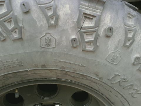 1995 Ford Bronco - A close-up view of a tire's tread pattern, showing a crack and manufacturer markings.