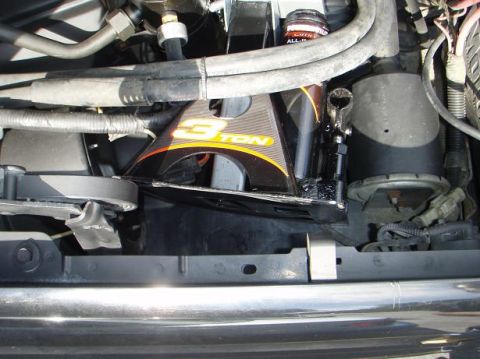 1995 Ford Bronco - Close-up view of engine bay components, including a "3 TON" bracket and various hoses.