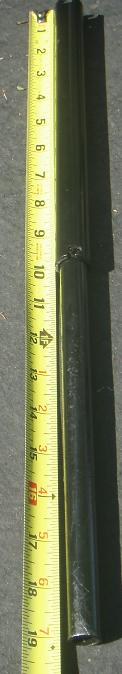 1995 Ford Bronco - A black metal part is shown next to a yellow tape measure, indicating its length.