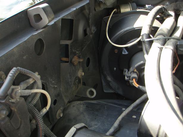 Engine bay close-up showing wiring harnesses and a black blower motor housing