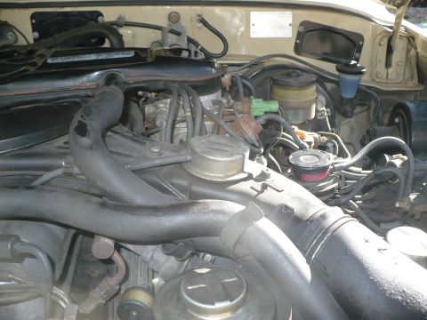 1986 Toyota Land Cruiser - The engine bay of a 1986 Toyota Land Cruiser is visible, with hoses and engine components clearly depicted.