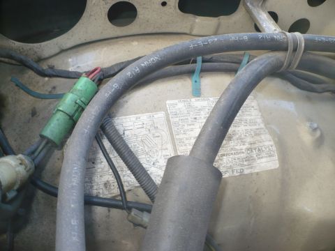 1986 Toyota Land Cruiser - Close-up of engine bay components and a vehicle emission control information sticker.
