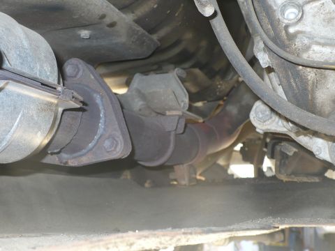 1986 Toyota Land Cruiser - This image shows a close-up view of the exhaust system's connection point, likely a catalytic converter or muffler joint.