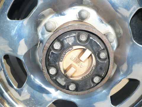 1986 Toyota Land Cruiser - This is a close-up view of a vehicle's wheel, specifically showing an Aisin manual locking hub with clear markings for 'LOCK' and 'FREE'.