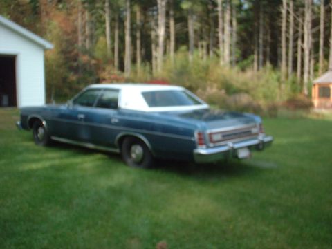 1975 Ford LTD - This 1975 Ford LTD sedan is parked on a grassy lawn with a wooded area in the background.