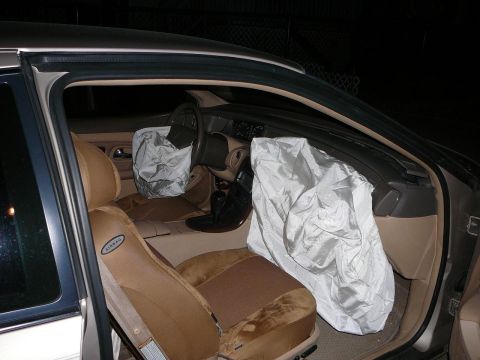 1997 Lincoln Mark VIII - The interior of a 1997 Lincoln Mark VIII shows deployed airbags and tan upholstery.