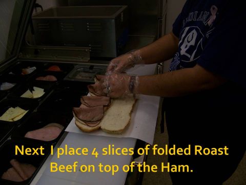 1989 Ford Bronco - A person is shown adding roast beef slices to a sandwich in a food preparation area.