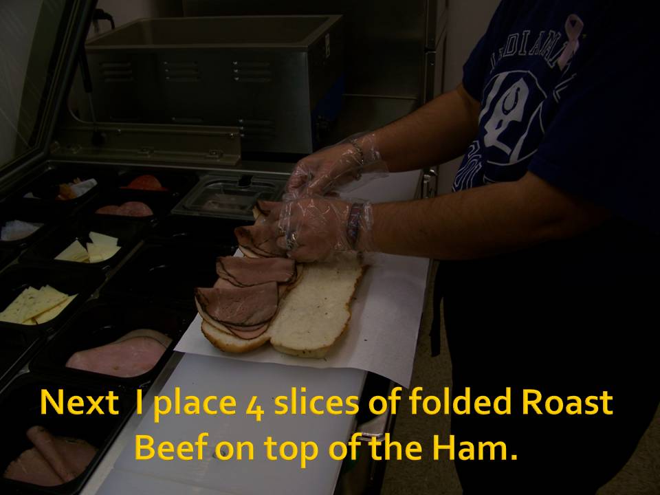 Person adding roast beef slices to a sandwich