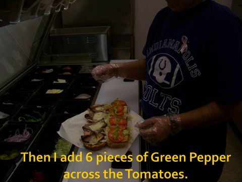 1989 Ford Bronco - A person is assembling a sandwich with various ingredients in a food service establishment.