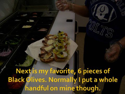 1989 Ford Bronco - Sandwiches are being prepared with various toppings, including olives, in a food service establishment.
