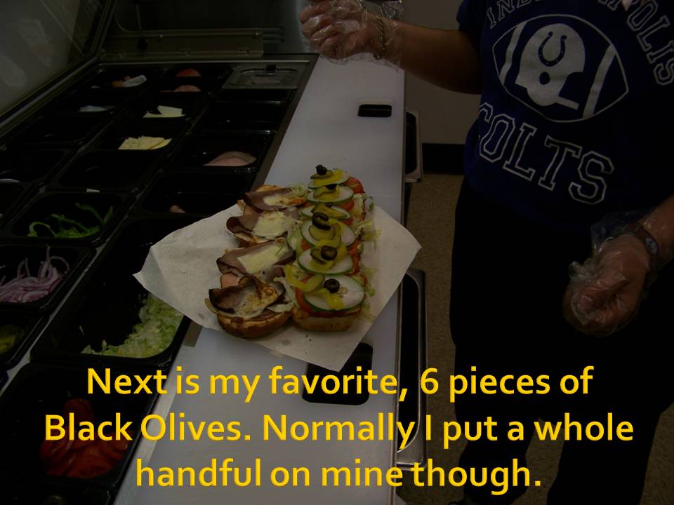 person making sandwiches with olives and other toppings