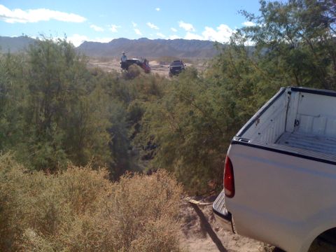 1989 Ford Bronco - Two off-road vehicles are visible in the distance, with a pickup truck in the foreground.