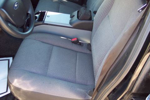 2001 Ford Crown Victoria - The interior of a police car, likely a 2006 Ford Crown Victoria, is visible with gray fabric seats and a center console.