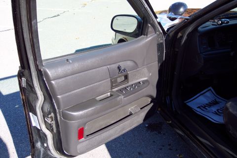 2001 Ford Crown Victoria - Interior view of a 2001 Ford Crown Victoria, showing the driver's side door panel and dashboard with a "Thank You" mat on the floor.